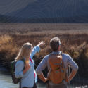 Couple Standing by River Surveying Landscape