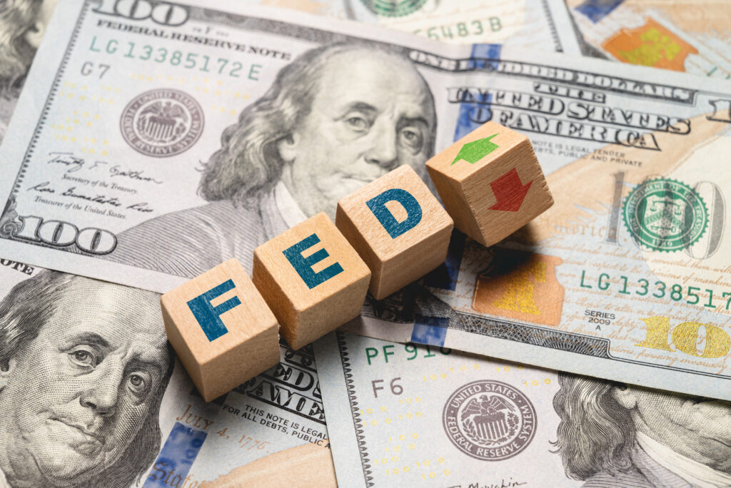 Wooden cubes with FED and up-down arrows over 100 usd. Fed rate hike concept to curb inflation